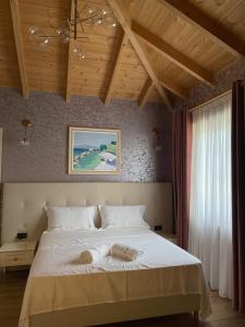 1 dormitorio con 1 cama grande con sábanas blancas en Agroturizem Eldi en Fier