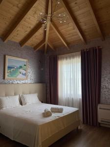 - une chambre avec un grand lit blanc et une fenêtre dans l'établissement Agroturizem Eldi, à Fier