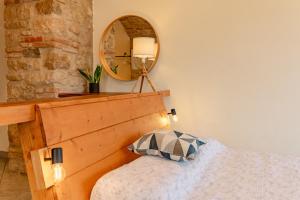 a bedroom with a wooden headboard and a mirror at Studio with private garden by GardaDoma in Brenzone sul Garda