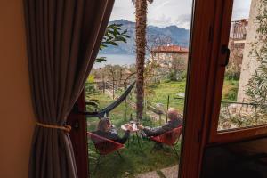 a man and woman sitting at a table looking out a window at Studio with private garden by GardaDoma in Brenzone sul Garda