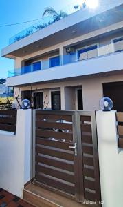 una casa con una puerta de madera delante de ella en Villa Marina ixia, Rodos, en Ixia