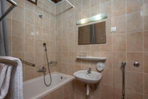 La salle de bains est pourvue d'un lavabo, d'une douche, d'une baignoire et d'un miroir. dans l'établissement Uvala Scott, à Kraljevica