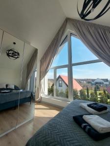 a bedroom with a large window and a bed at Lantern Hill Jastrzębia Góra in Jastrzębia Góra