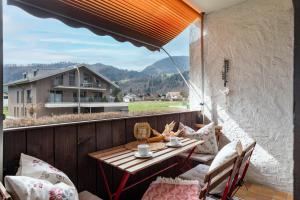 un patio con tavolo e sedie sul balcone. di Ferienwohnung Brünnstein - Alpenmagie Suites a Oberaudorf