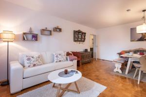 a living room with a white couch and a table at Ferienwohnung Brünnstein - Alpenmagie Suites in Oberaudorf