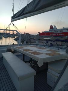 einen Tisch und Bänke auf einem Boot mit einem Kreuzfahrtschiff in der Unterkunft Santa-Giulia in Propriano