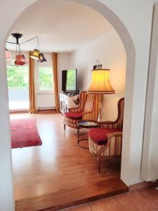 sala de estar con un arco con sillas y TV en Haus Mediterran - Gemütliches Ferienhaus 130 m² für max. 7 Personen mit Balkon und Garten am Bodensee en Radolfzell am Bodensee