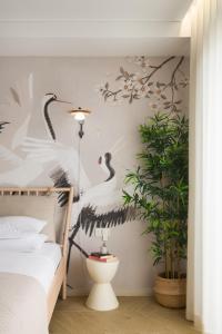 1 dormitorio con un mural de aves en la pared en Eagle's Nest Ljubljana, en Liubliana