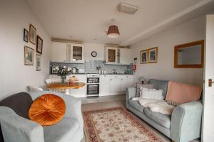a living room with two couches and a kitchen at The Linhay at Hewish Mill in Barnstaple