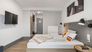 a bedroom with a bed and a tv on a wall at SMARTments connect Frankfurt City Ost in Frankfurt/Main