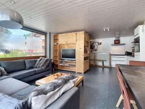 a living room with a couch and a tv at Mont Caly - appartement - 8 pers - centre in Les Gets +6 photos