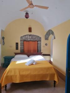 ein Schlafzimmer mit einem großen Bett und einem Steinkamin in der Unterkunft Dimora Coloniale B&B in Ischia