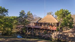 een resort met een terras waar mensen op zitten bij Ndlovu Safari Lodge in Welgevonden Wildreservaat