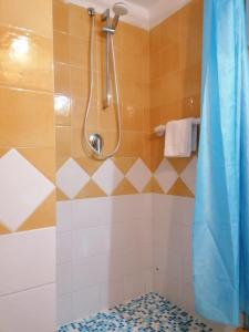 La salle de bains est pourvue d'une douche, de toilettes et d'un rideau de douche. dans l'établissement Dimora Coloniale B&B, à Ischia