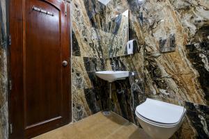 a stone bathroom with a toilet and a sink at Hotel Legend - Walk-In from New Delhi Railway Station in New Delhi