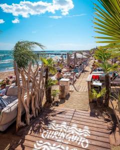 a wooden boardwalk on a beach with chairs and palm trees at MOBILE HOME CLIMATISE Vias 2 in Vias