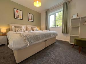 a bedroom with a large bed and a window at Charming 3-bed Home In Bourne in Lincolnshire