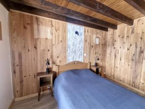 una camera da letto con una parete in legno, un letto e una finestra di Cornuts 3 - appartement - 7pers a Les Gets