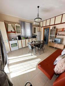 una cucina e un soggiorno con tavolo e sedie di Orfeas Sea View House a Archangelos