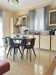 a kitchen with a dining room table and chairs at Orfeas Sea View House in Archangelos