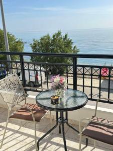 un tavolo e sedie su un balcone con vista sull'oceano di Orfeas Sea View House a Archangelos