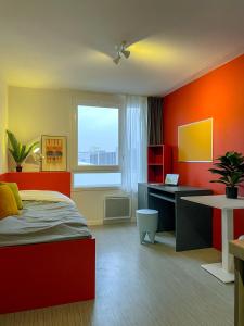 a bedroom with a bed and a desk and a window at ART'CAMPUS PLAINE IMAGES in Roubaix