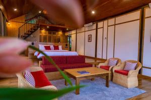 a room with a bed and a couch and a table at amã Stays & Trails Eagle's Nest, Gangtok, Sikkim in Bhurtuk