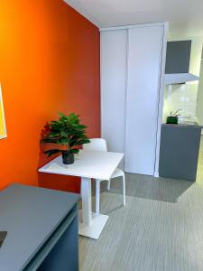 une chambre avec une table blanche et une plante en pot dans l'établissement ART'CAMPUS PLAINE IMAGES, à Roubaix