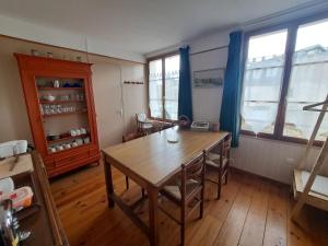 une salle à manger avec une table en bois et des rideaux bleus dans l'établissement LOCATION à COUCY LE CHATEAU, à Coucy-le-Château-Auffrique