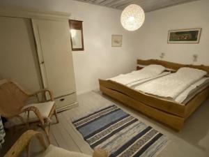 a bedroom with a bed and a chair and a rug at HavetÖsterlen -Sandpärlan 8 & Sandboxen 2 in Borrby