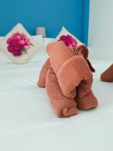 a brown teddy bear laying on a bed at Phannarai House in Lamai