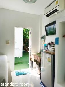 una cucina con frigorifero e una porta che conduce a un cortile. di Phannarai House a Lamai Beach