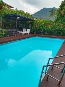 a large blue swimming pool with a table and chairs at Phannarai House in Lamai