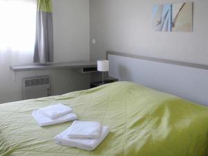 - un lit avec 2 serviettes assises au-dessus dans l'établissement Les les Anglo Normandes holiday resort Portbail, à Portbail
