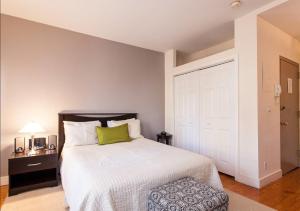 una camera con un letto bianco e un cuscino verde di Gorgeous Apt for 2! Heart of Manhattan! a New York