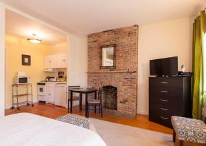 a bedroom with a brick fireplace with a table and chairs at Gorgeous Apt for 2! Heart of Manhattan! in New York