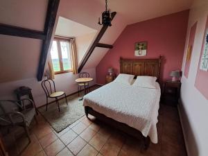 - une chambre avec un lit, une table et des chaises dans l'établissement LOCATION à COUCY LE CHATEAU, à Coucy-le-Château-Auffrique
