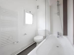 y baño blanco con aseo y bañera. en Holiday resort Golfe du Morbihan Larmor Baden acc for 4 pers, en Larmor-Baden