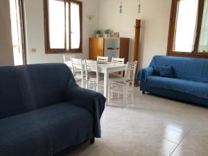 uma sala de estar com um sofá azul e uma mesa em Casa Maris em Torre Grande