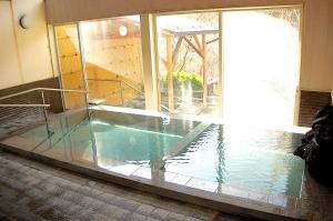 a swimming pool in a room with a window at Sawatari Onsen Miyataya Ryokan in Nakanojo