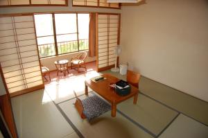 een kamer met een tafel en stoelen. bij Sawatari Onsen Miyataya Ryokan in Nakanojo