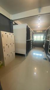 an empty room with lockers and a large room with a room at W District Guesthouse in Bangkok