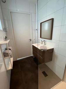 y baño con lavabo y espejo. en Bembom Hoeve Guesthouse, en Lutten