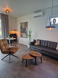 sala de estar con sofá y mesa en Bembom Hoeve Guesthouse, en Lutten