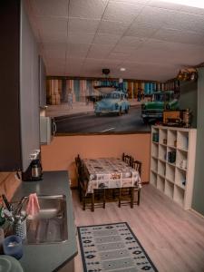 een keuken met een tafel en een keuken met een auto bij Hostel Majatalo Hetekka in Kouvola