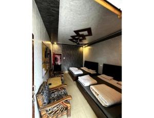 a room with three beds and a ceiling at Anu Shree Lodge, Ukhimath in Ukhimath
