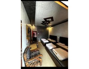 a room with two beds and a ceiling at Anu Shree Lodge, Ukhimath in Ukhimath