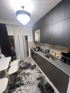 a kitchen with a sink and a table and a chandelier at Lux Istanbul City in Yakkasaray