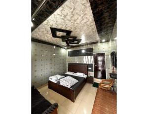 a bedroom with a bed and a ceiling at Anu Shree Lodge, Ukhimath in Ukhimath