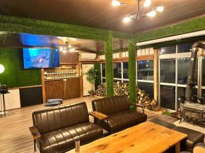 飯山市にあるゲストハウスみどりのソファ、テーブル、テレビが備わる客室です。